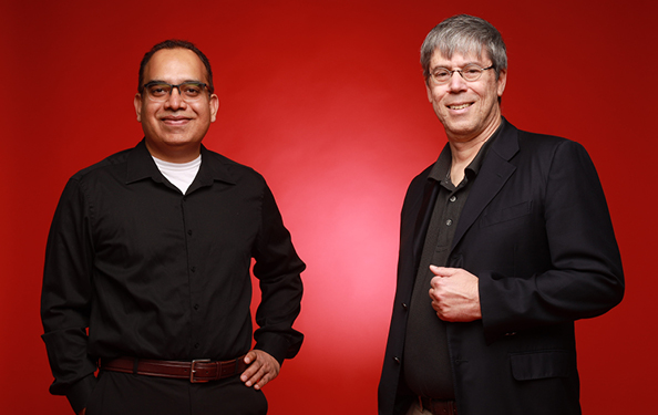 Asheesh Singh and Pat Schnable stand in front of a red background
